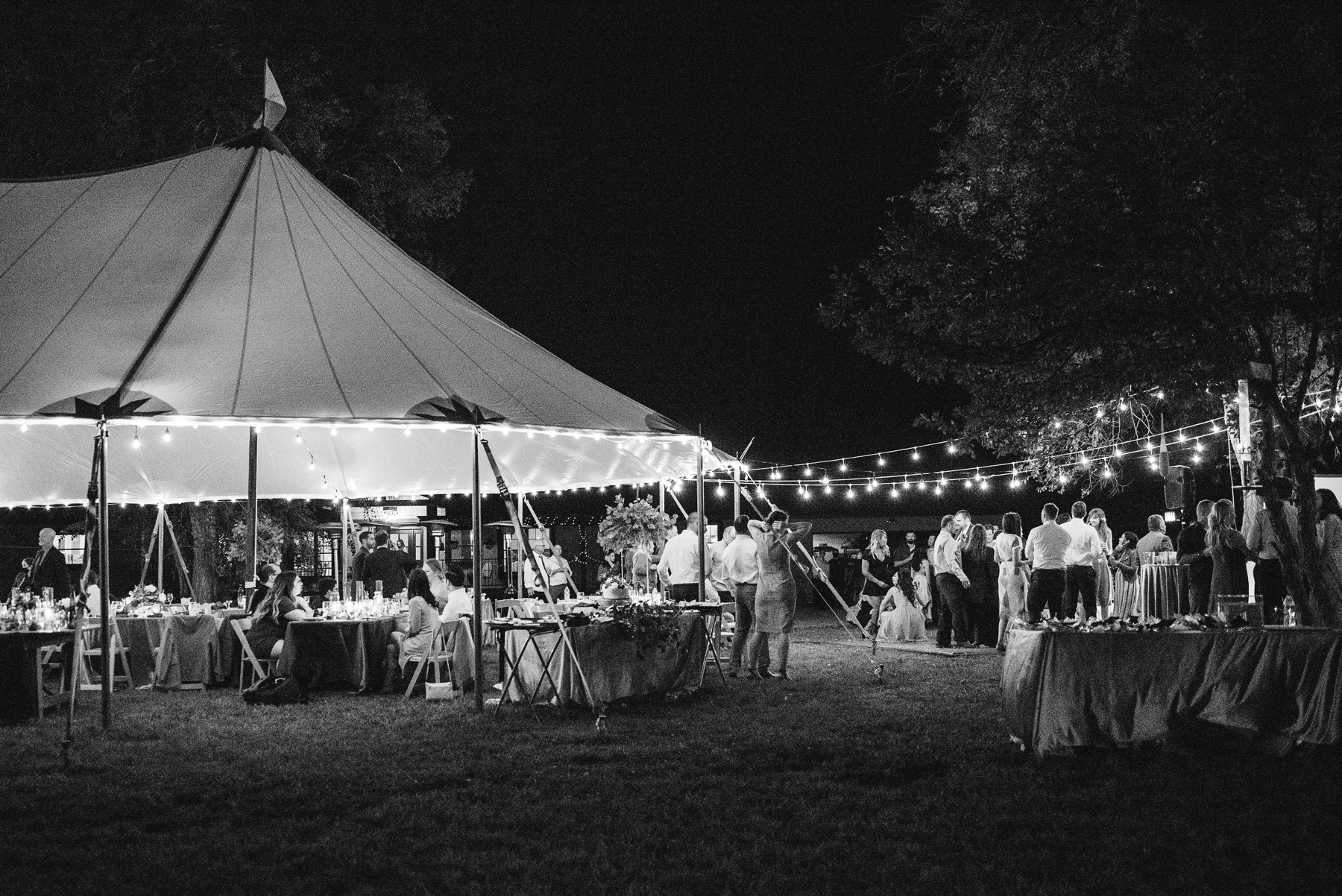 Tented Wedding Reception guests and edison lights
