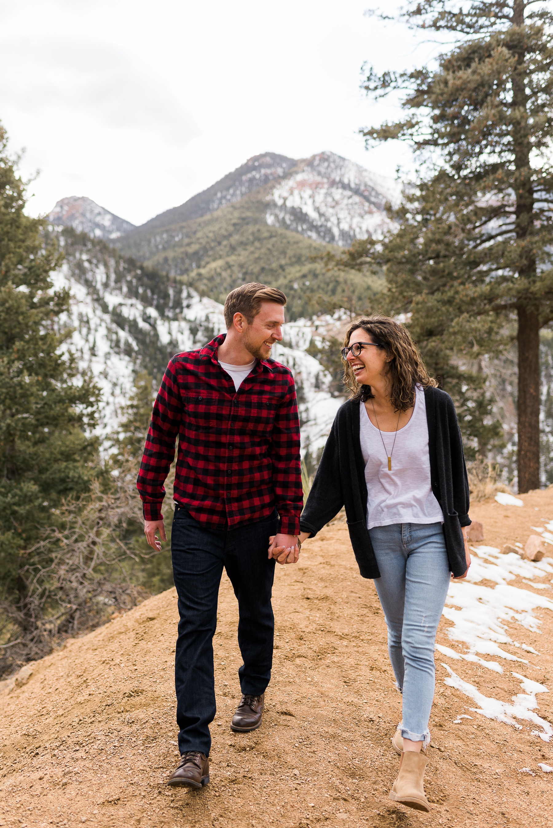 Couple holding hands and smiling with mountains in background