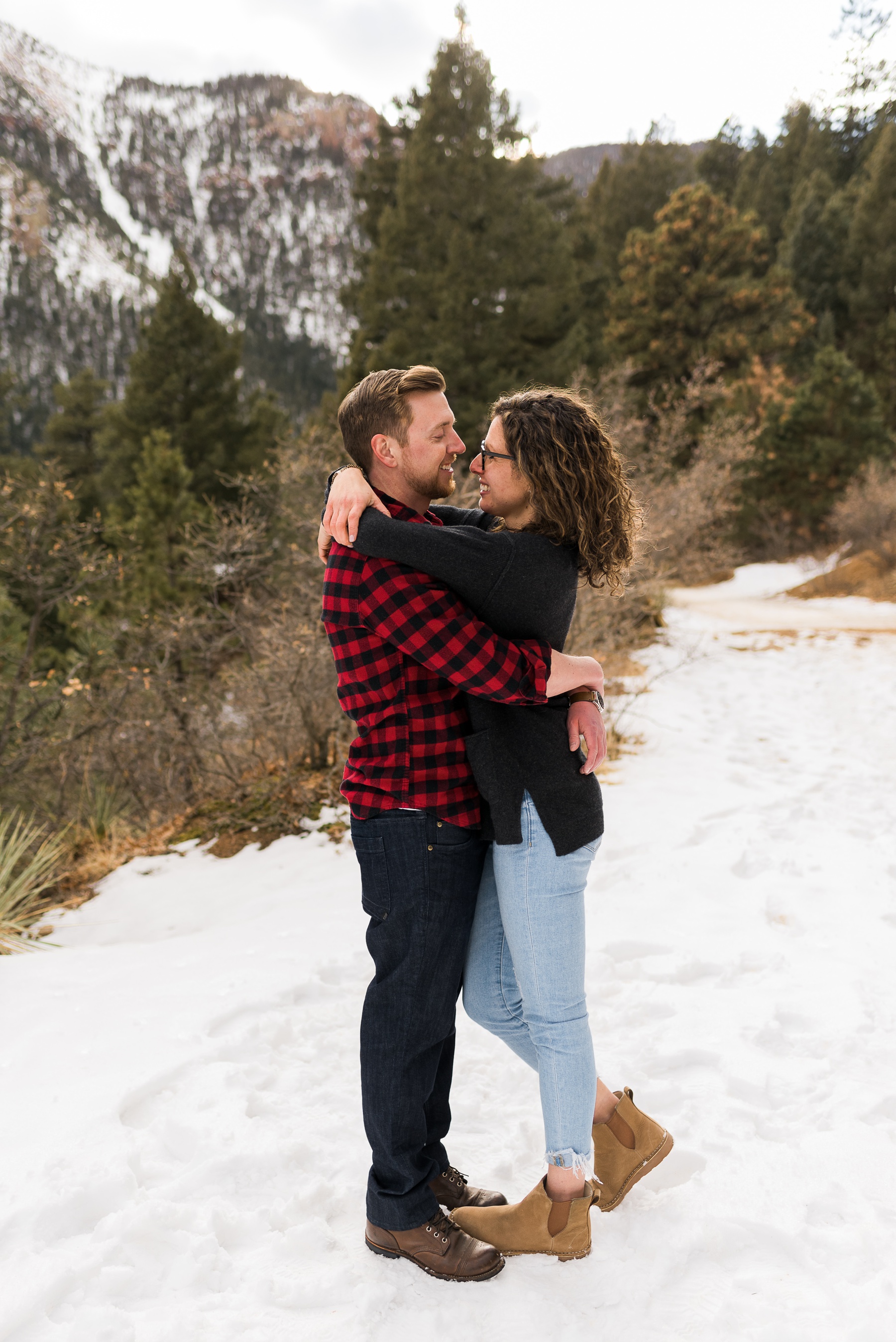 couple holding each other and smiling in mountains