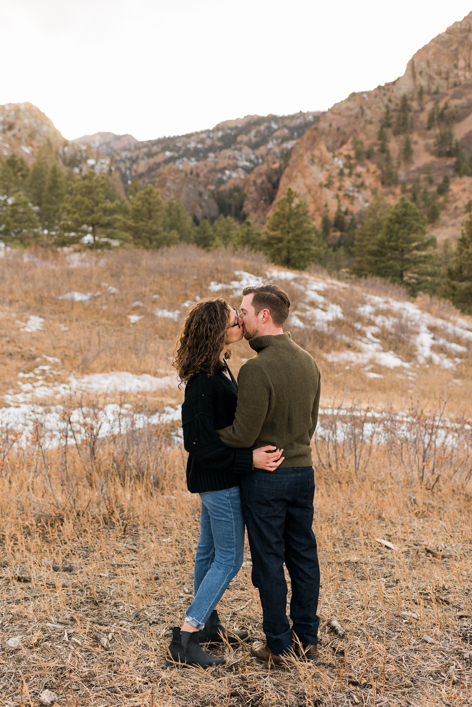 couple kissing with mountains in background