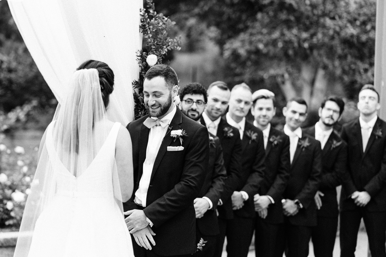 Groom smiling at bride during vows.