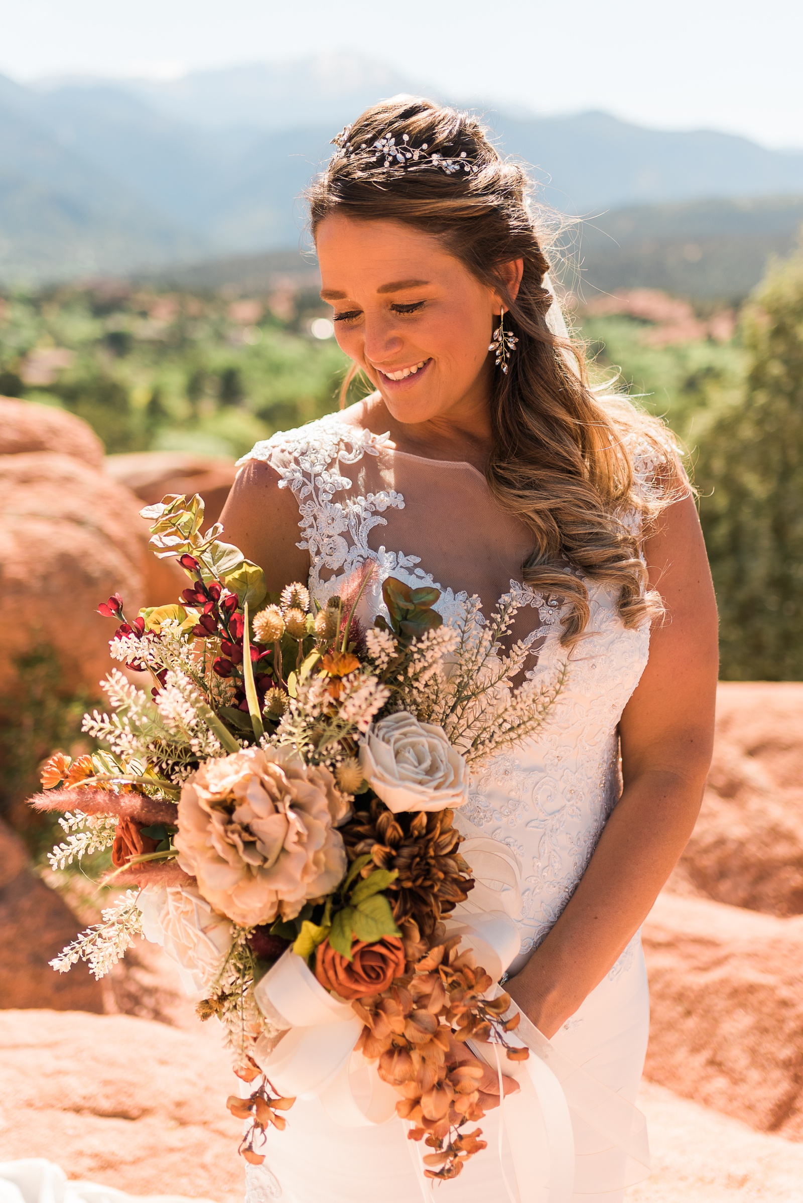 Bride smiling and looking down at flowers