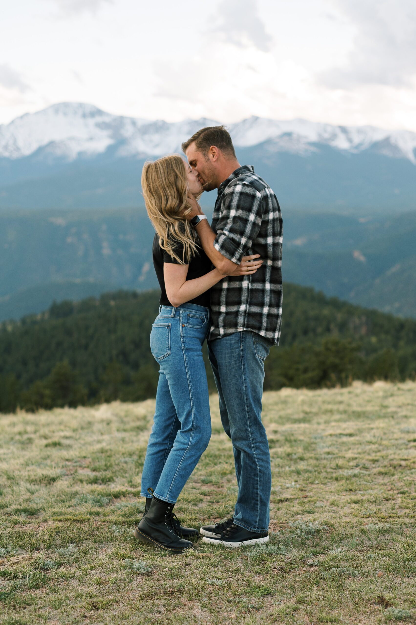 Couple kissing with views of mountains in background.